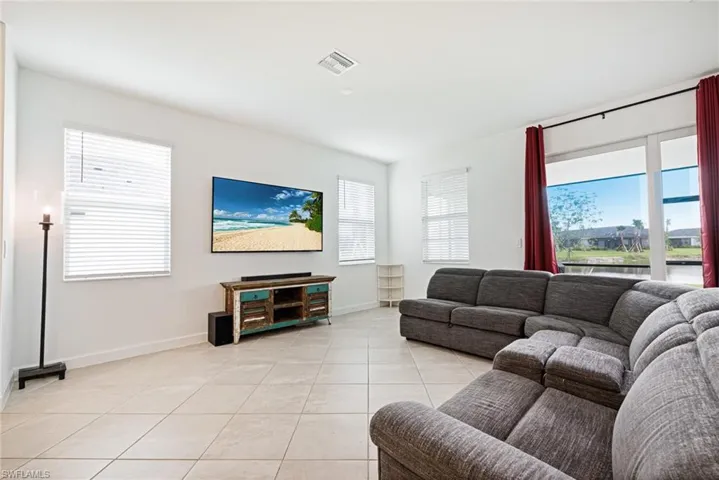 Living room with light tile patterned floors and healthy amount of natural light