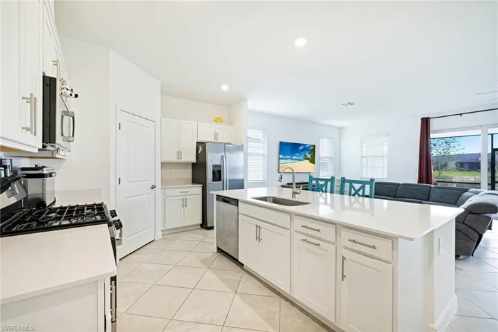 Kitchen featuring stainless steel appliances, light tile patterned flooring, white cabinetry, light countertops, and recessed lighting