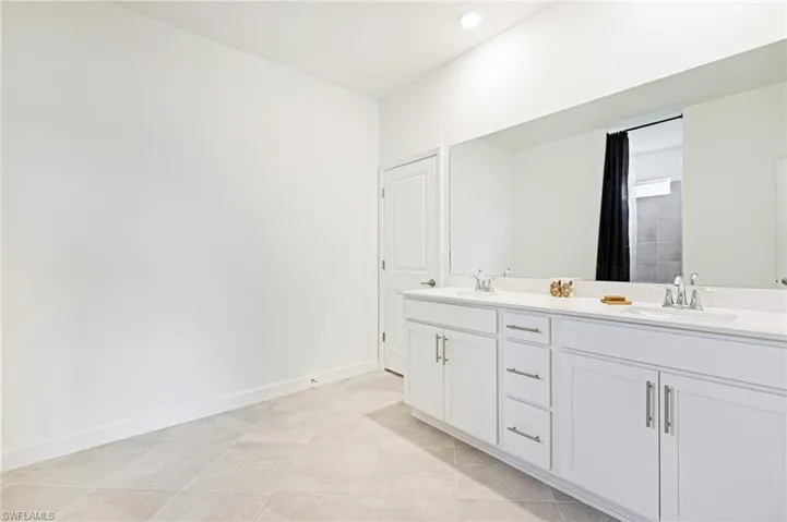 Full bathroom with double vanity, recessed lighting, and tile patterned flooring