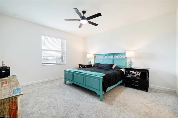 Bedroom with light colored carpet and ceiling fan