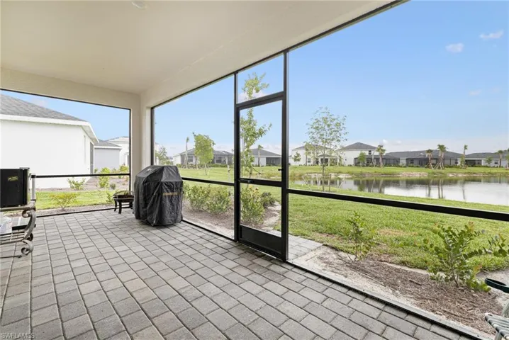 Sunroom with a residential view and a water view