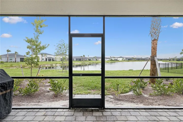 Unfurnished sunroom featuring a water view and a residential view