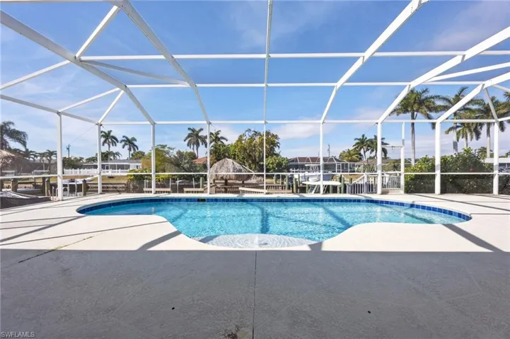 Swimming pool with a lanai, a sunroom, and a patio