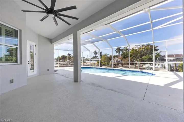 Swimming pool featuring a patio area, a sunroom, and a lanai