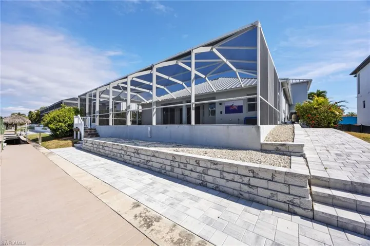 Back of house featuring glass enclosure and a sunroom