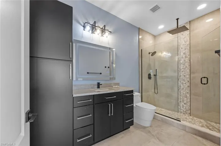 Bathroom featuring vanity, a shower stall, and recessed lighting