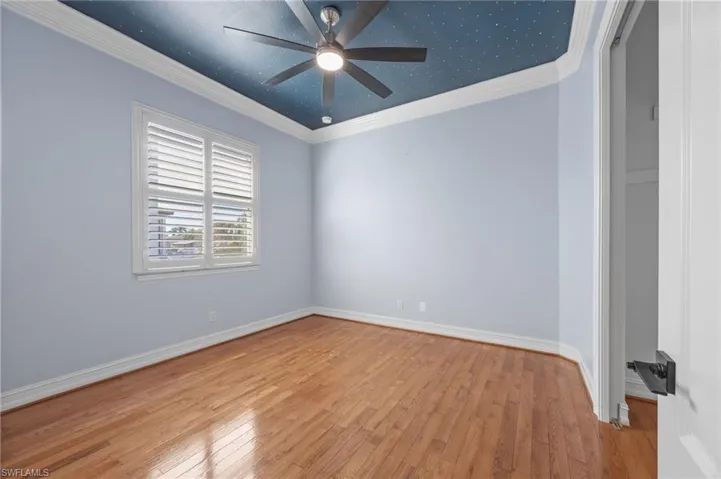 Spare room featuring crown molding and hardwood / wood-style floors