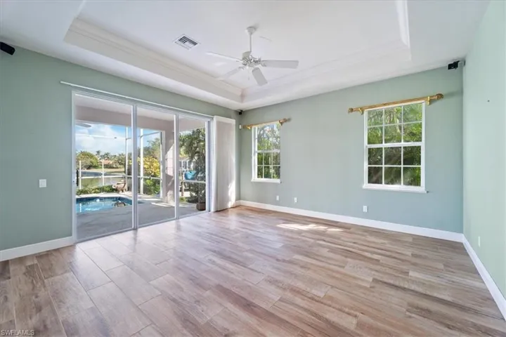 Unfurnished room with ceiling fan, crown molding, light hardwood / wood-style floors, and a raised ceiling