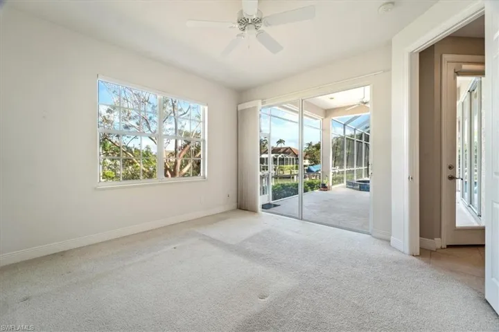 Carpeted empty room with plenty of natural light and ceiling fan