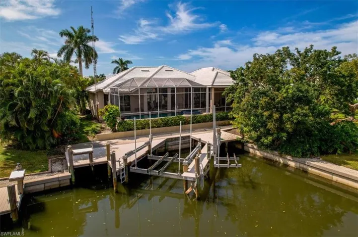 Dock area featuring a pool, glass enclosure, and a water view