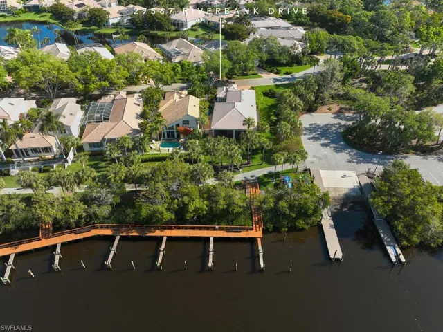Aerial rear view. This home sits at the water's edge to the right. Boat ramp and park are to the right.