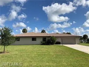 Ranch-style house with a front yard, driveway, and an attached garage