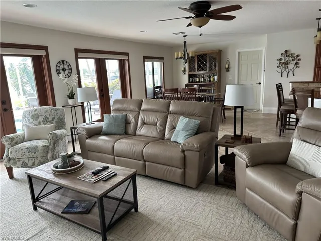 Living room with french doors, ceiling fan, a textured ceiling, and tile patterned floors