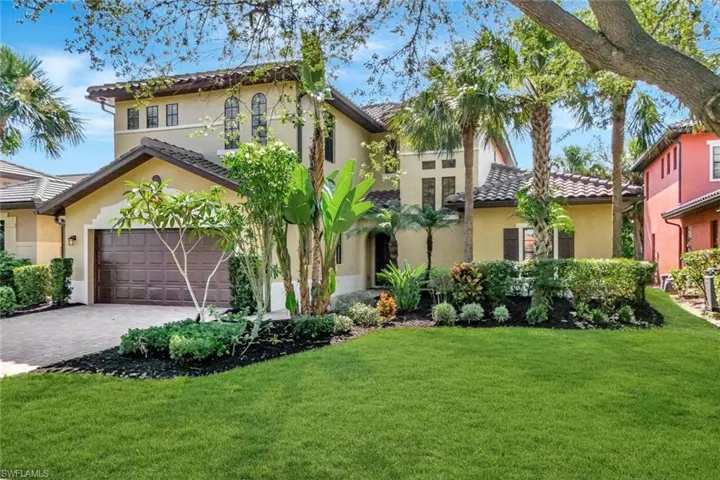 House with a front lawn, stucco siding, and decorative driveway
