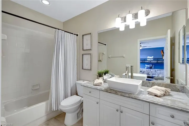 Full bathroom with vanity, connected bathroom, shower / tub combo, and tile patterned flooring