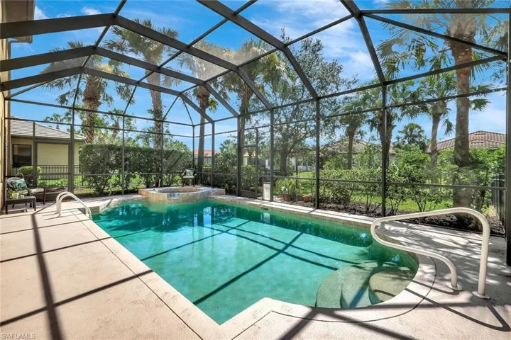 View of swimming pool featuring a patio, a pool with connected hot tub, and screened enclosure