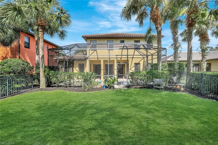Rear view of house featuring a fenced backyard, stucco siding, and lanai