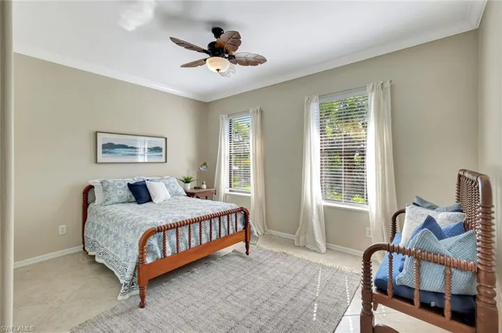 Bedroom with ornamental molding, a ceiling fan, and light tile patterned floors