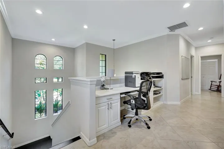 Office space with recessed lighting, crown molding, light tile patterned floors, and built in desk