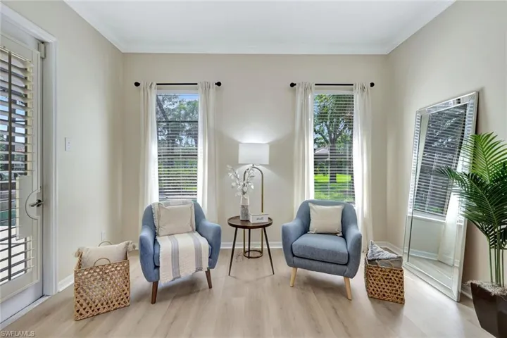 Living area featuring light wood-type flooring and ornamental molding