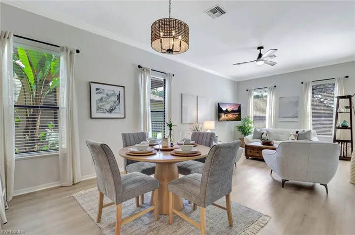 Dining space with crown molding, light wood-style flooring, and ceiling fan