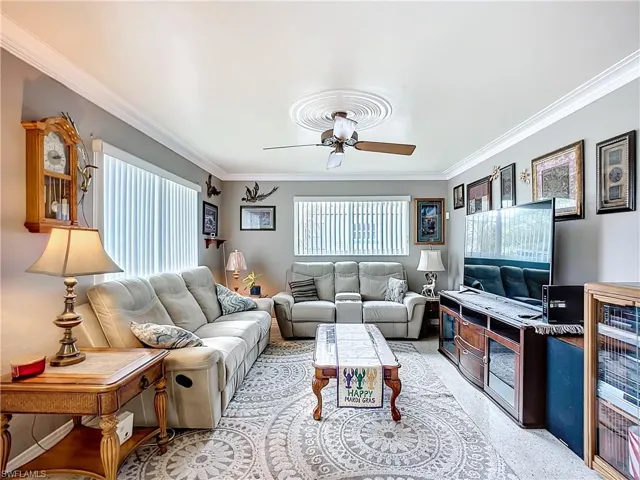 Living area with ornamental molding and ceiling fan