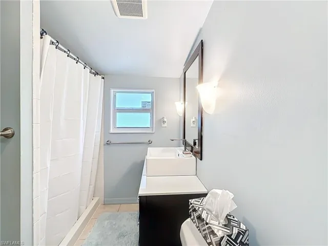 Bathroom featuring visible vents, vanity, a shower stall, and tile patterned floors