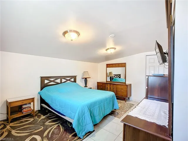 Bedroom featuring vaulted ceiling and light tile patterned flooring