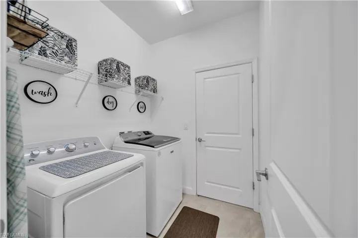 Laundry area featuring washing machine and dryer and light tile patterned flooring