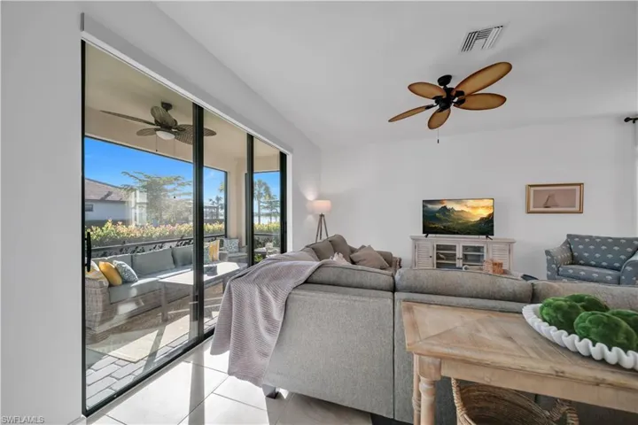 Living room with ceiling fan and light tile patterned floors