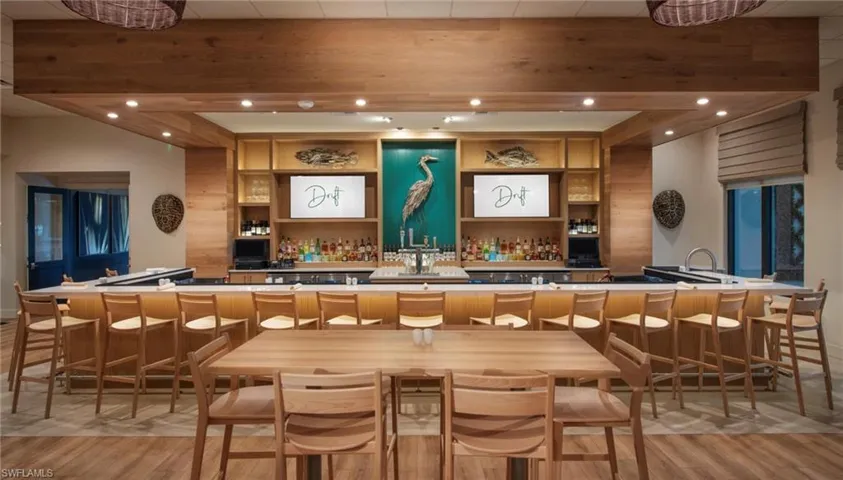 Indoor wet bar featuring open shelves, recessed lighting, and light countertops