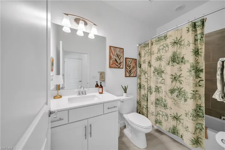 Bathroom featuring shower / tub combo with curtain and vanity