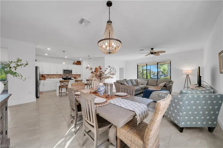 Dining area with light tile patterned floors, a chandelier, recessed lighting, and a ceiling fan