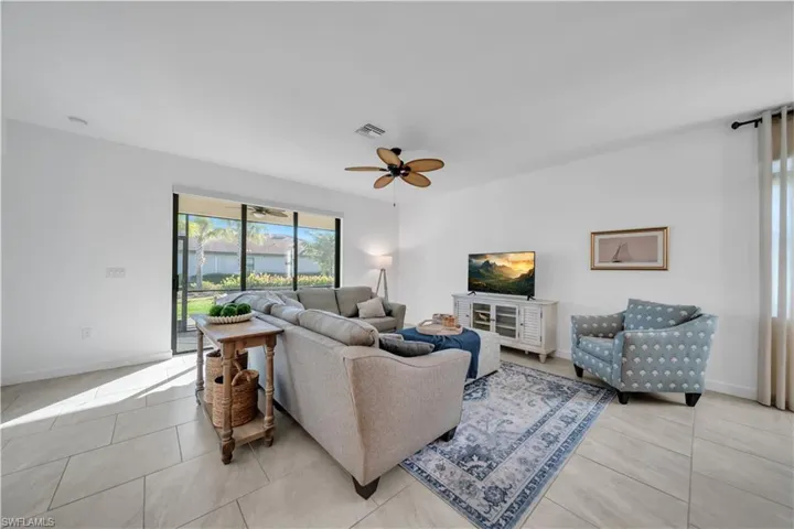 Living area with ceiling fan and light tile patterned flooring