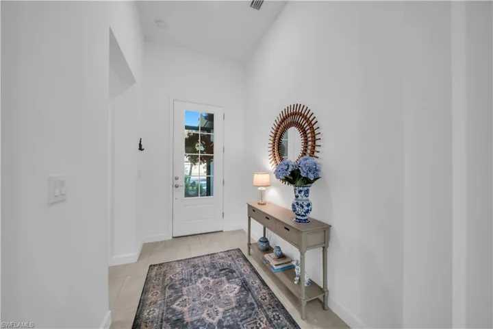 Entryway with baseboards and light tile patterned flooring