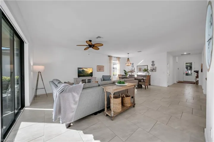 Living area with light tile patterned flooring and a ceiling fan