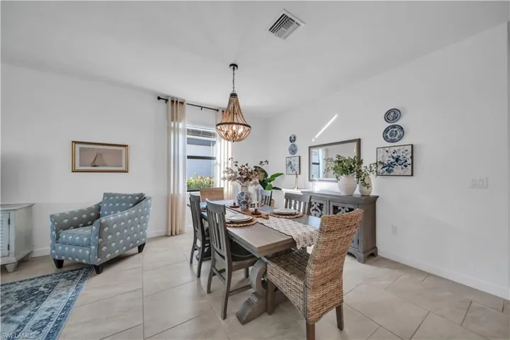 Dining space with light tile patterned floors and a chandelier