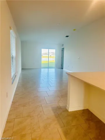 Spare room featuring baseboards and light tile patterned flooring