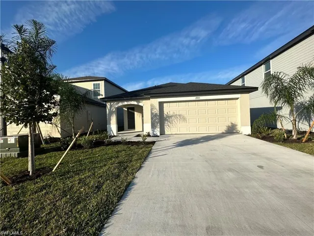 View of front of house featuring stucco siding, driveway, an attached garage, and a front lawn