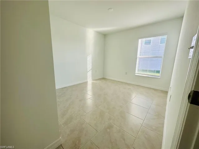 Unfurnished room featuring baseboards and light tile patterned floors