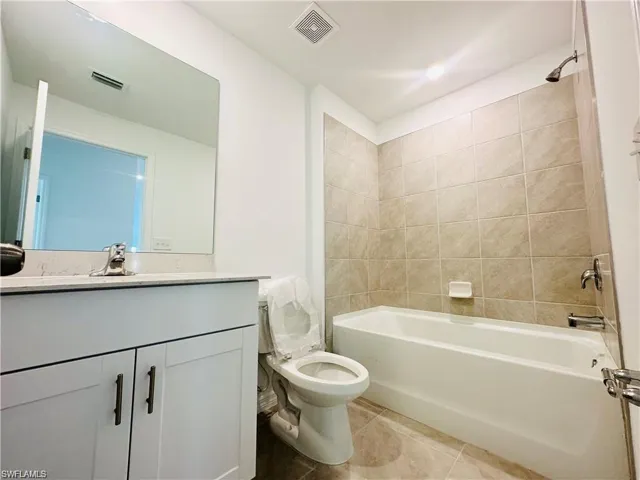 Full bathroom featuring shower / tub combination, vanity, and light tile patterned floors
