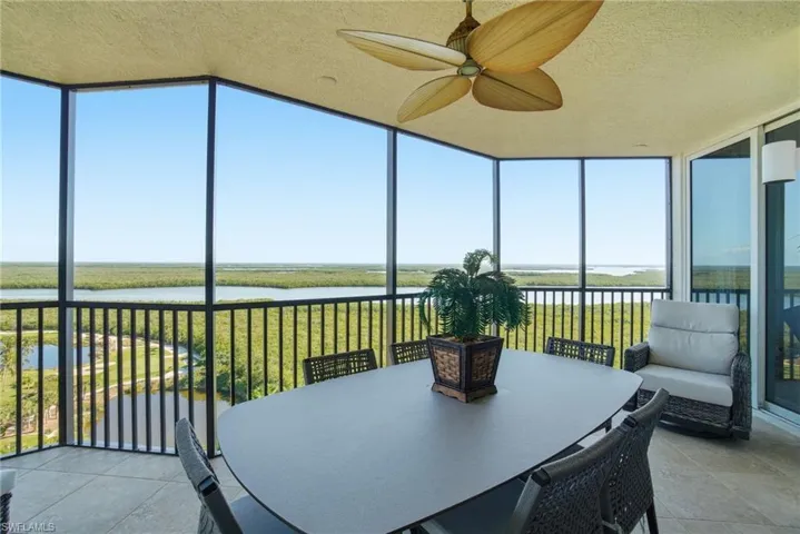 Sunroom / solarium featuring floor to ceiling windows, a water view, tile patterned floors, and a textured ceiling