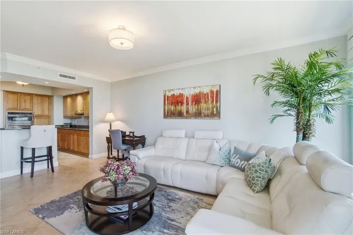 Living area with crown molding and baseboards