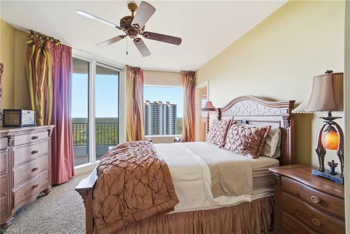 Carpeted bedroom featuring access to exterior and a ceiling fan