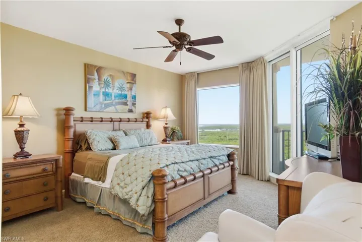 Carpeted bedroom featuring access to exterior and a ceiling fan