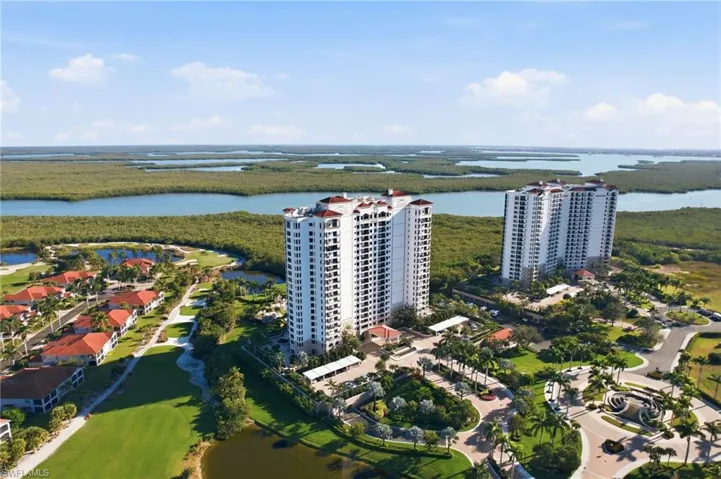 Drone / aerial view of a nearby body of water and apartment complex