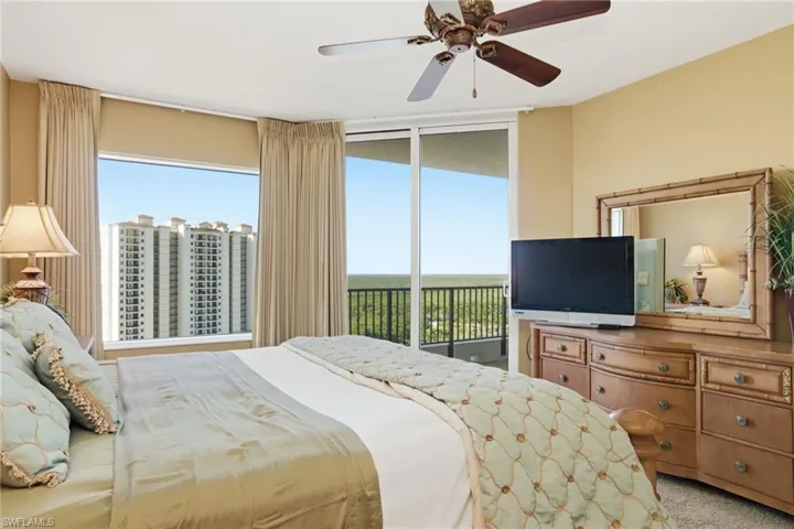 Bedroom with access to exterior, light colored carpet, and ceiling fan