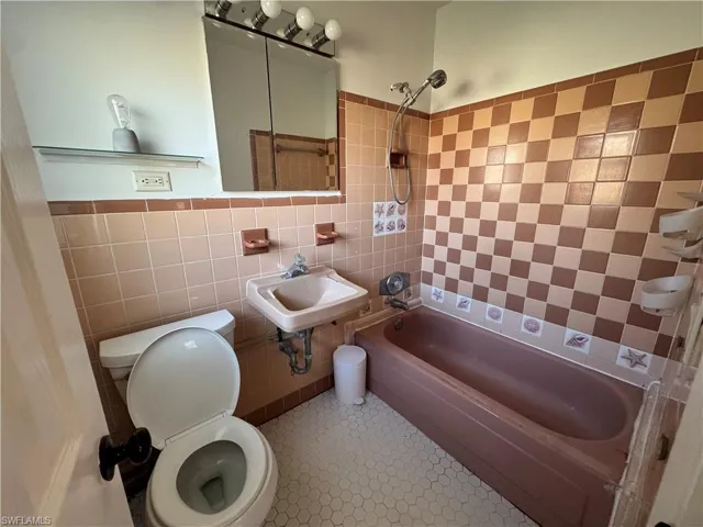 Unfurnished bedroom with a closet, wood finished floors, visible vents, and baseboards