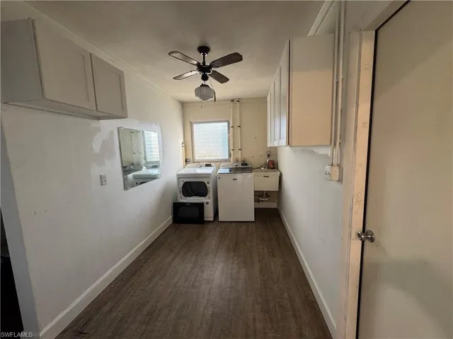 Hall with baseboards, electric water heater, and wood finished floors