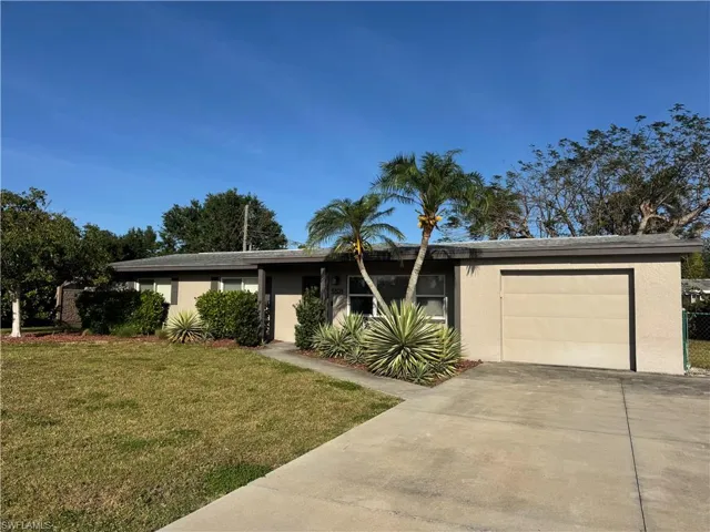 Ranch-style house featuring an attached garage, concrete driveway, a front lawn, and stucco siding